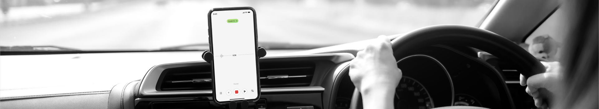 A woman in a car records her voice on a phone